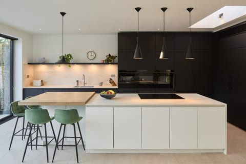 Super-matt white and black cabinetry with a textured ceramic Dekton worksurface in a Beckenham kitchen.