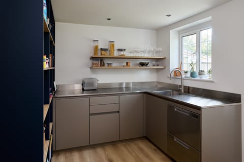 A tall Leicht cabinetry wall in Fenix Boreal Green at the Hever Colour & Stainless Steel Kitchen — full-height matt green fronts.