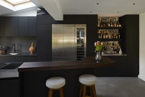 Eltham Dark Gaggenau Kitchen — a dark social kitchen with a dedicated drinks area, Gaggenau cooling and a Danish timber-topped island.