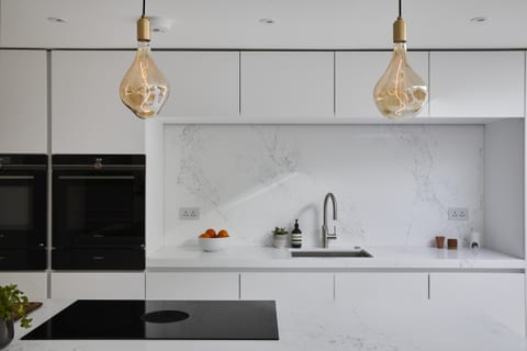 Bright white cabinetry with Caesarstone surfaces in a Meopham kitchen.