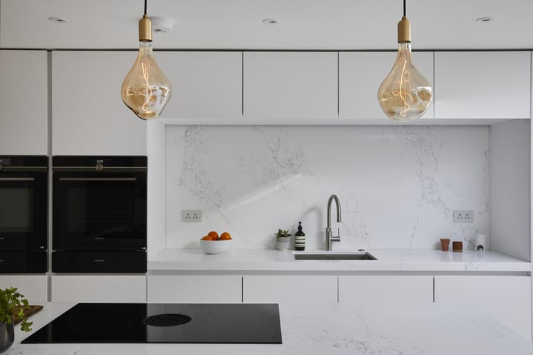 Bright white cabinetry with Caesarstone surfaces in a Meopham kitchen.